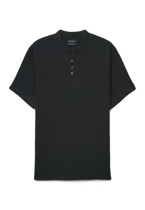 Chemise noire à manches courtes avec un col rond et quatre boutons en bois sur la patte de boutonnage avant, fabriquée en tissu texturé.