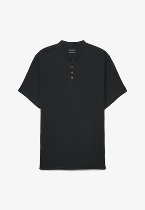Schwarzes Kurzarmhemd mit rundem Kragen und vier Holzknöpfen entlang der vorderen Knopfleiste, aus strukturiertem Stoff gefertigt.