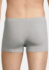 Gray cotton boxer shorts with a smooth texture and a simple elastic waistband, showing a close fit around the hips and thighs.