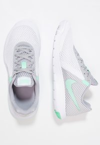 Zapatillas Nike con un upper de malla blanca y gris, con acentos en verde menta, un collar acolchado y una suela texturizada.