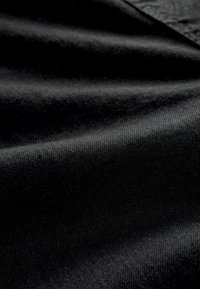 Black cotton fabric with a smooth texture, featuring a subtle sheen and light creases, showing depth and dimension in the material.