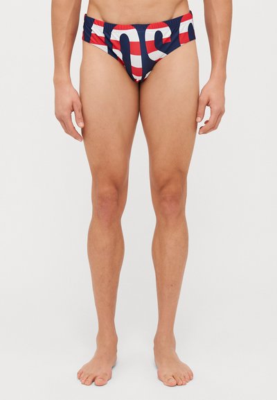Slip da nuoto con una fantasia a strisce rosse e bianche su sfondo blu navy. Presentano una cintura elastica e un design aderente per il massimo comfort.