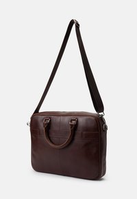 Barna bőr laptop táska dupla felső fogantyúval, állítható vállpánttal, keskeny téglalap alakú formával és minimalista dizájnelemekkel.