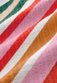 Tela a rayas multicolores que presenta tonos de rosa, rojo, blanco, verde y marrón. Textura suave con un patrón de suaves estrías.