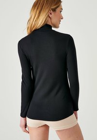 Maglietta nera a maniche lunghe con collo alto, realizzata in tessuto elasticizzato. Presenta un design elegante con una texture liscia e un orlo curvo.