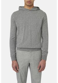 Grau gestrickter Kapuzenpullover mit Kordelzug, langen Ärmeln und geripptem Saum. Kombiniert mit hellgrauen, taillierten Hosen. Glatte Textur.