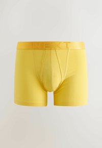 Boxeri galbeni pentru bărbați, cu buzunar conturat și talie elastică, cu numele mărcii "NEXT" embosat.