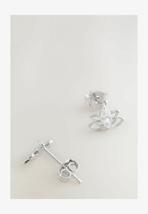 Sølvøreringe med marquise-slebne klare ædelsten og åben bladdesign på en lys baggrund.