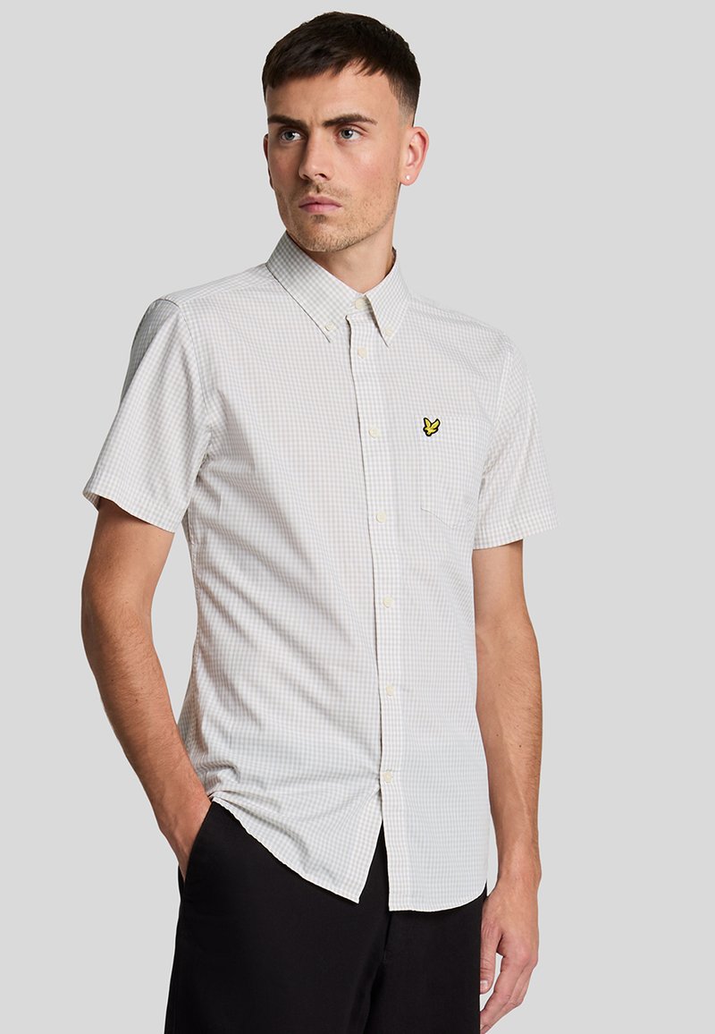 Camicia a maniche corte a quadri di colore grigio chiaro con un logo a farfalla gialla sul lato sinistro del petto e colletto button-down.