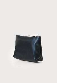 Beauty case nero lucido con forma strutturata, chiusura con zip e superficie liscia. Misura circa di dimensioni medie per un uso portatile.