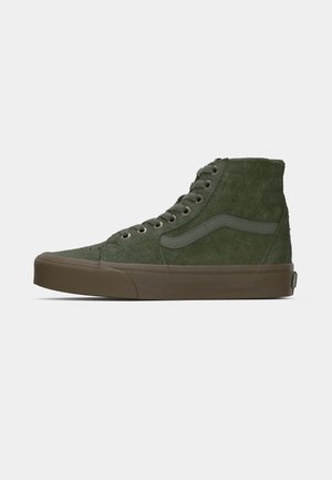 Höga sneakers i olivgrön mocka, med en ton-i-ton rand, brun gummisula och metalldetaljer för snörningen.
