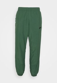 Zelené lehké jogger kalhoty s elastickým pasem, stahované na kotnících, s malým černým logem na levém stehně. Hladká textura.