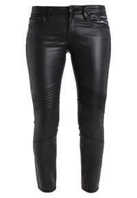 Pantalon noir ajusté avec des détails côtelés au-dessus des genoux, des poches zippées à l'avant et une fermeture par bouton à la taille.