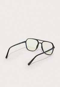 Mustad musta raamiga prillid selgete läätsedega. Elegantne disain sisaldab õhukesi, ümarate otsadega vahekangaid ja minimaalset riistvara. Sobivad erinevateks olukordadeks.