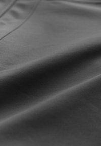 Dark gray fabric with a smooth texture, showing subtle draping and slight sheen, featuring clean lines and minimal design details.