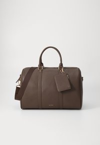 Brown leather duffel bag with gold hardware, dual handles, and a detachable shoulder strap. Includes a matching luggage tag. Textured finish.