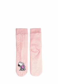 Calzini rosa lavorati a maglia con un motivo a trecce, con una grafica di Snoopy che tiene un cuore su un lato e pois bianchi sulla suola per una migliore aderenza.