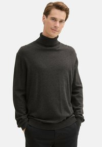 Czarny sweter z golfem w ciemnoszarym kolorze, z długimi rękawami, wykonany z miękkiego materiału, z luźnym krojem oraz ściągaczami przy mankietach i na dole.