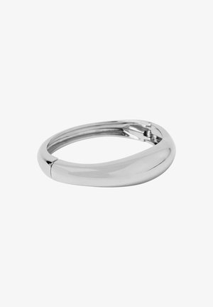 Smyckeband av slät, polerad silver med en rundad, lätt vriden form och ett litet gångjärnslås på vit bakgrund.