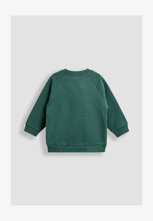 Zöld pulóver rugalmas ujjal, bordázott mandzsettákkal és hem. Puha tapintású, sima felületű. Nincsenek zsebek vagy további díszítések.