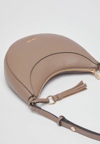 Sac à main en cuir marron de forme croissant, avec une fermeture éclair dorée et un accent en pampille. Comprend une bandoulière réglable et un logo embossé.