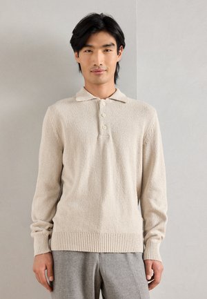 Beige långärmad polo skjorta med en texturerad tyg, tre-knapplåsning och ribbade muddar och nederkant.