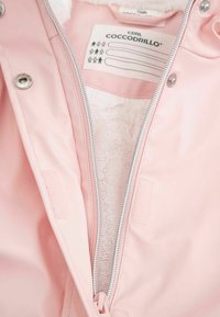 Różowa kurtka z zamkiem błyskawicznym, podszewka z białego, miękkiego futra sztucznego. Posiada srebrne akcesoria i zapięcia na rzep z przodu. Metka jest widoczna.