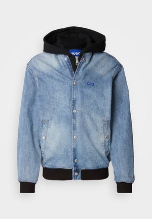 Light blue denim jacket with black hood, snap button closure, side pockets, ribbed cuffs, and a small blue brand logo on the chest.