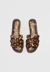 Brązowe klapki na slide z paskiem w leopardzie wzory, z teksturowaną podeszwą w wytłoczoną skórę krokodyla. Złote litery z brandingiem na wkładce.