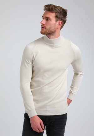 Crème coltrui met lange mouwen, geribbelde kraag en manchetten, aangesloten ontwerp, gladde textuur en subtiele schouderdetails.