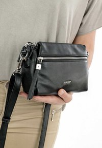 Borsa a tracolla nera in pelle con una finitura testurizzata, chiusura con cerniera argentata, tracolla staccabile e piccola tasca esterna con zip.