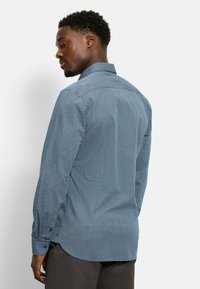 Langärmliges Hemd in Hellblau mit geometrischem Muster. Verfügt über einen klassischen Kragen und knöpfbare Manschetten, aus leichtem Stoff gefertigt.