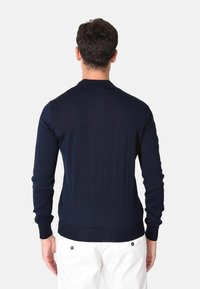 Cardigan a maglia blu navy con maniche lunghe, tessuto testurizzato e polsini a coste. Design semplice, con collo a polo e silhouette aderente.