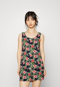 Top de alças florido com fundo azul-marinho, apresentando flores vermelhas e folhas verdes. Tecido suave; design sem mangas com decote arredondado.