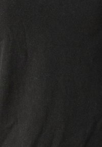 Tessuto di cotone nero con una texture liscia. Il materiale appare leggermente teso, mostrando un colore uniforme con minime variazioni visive.