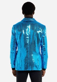 Mėlynas blizgučių švarkas su struktūruotu dizainu, su iškarpytu apykakle, vienu nugaros ventiliacijos pjūviu ir juodais akcentais ant rankovių.