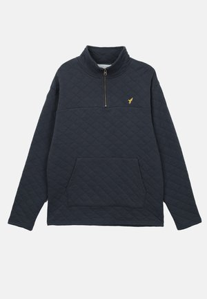 Pullover acolchoado em azul marinho, com gola de meio zíper, um bolso frontal e um pequeno emblema dourado no peito. Textura suave e corte descontraído.