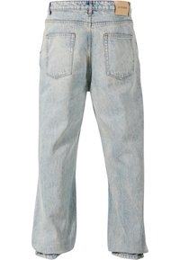 Světle modré džínové kalhoty s volným střihem, které mají dvě zadní kapsy, šité švy a štítek na pase. Textura vypadá měkce a opotřebovaně.