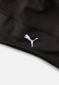 Czarna tkanina sportowa o gładkiej teksturze, z białym logo Puma. Projekt zawiera ciasne szwy i nowoczesny, elegancki wygląd.