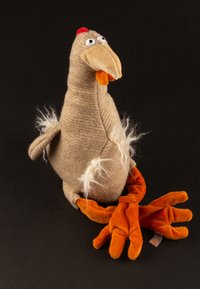 Stuffed chicken toy with a textured beige body, orange cloth feet, and a red comb. Features big round eyes and fluffy accents on wings.