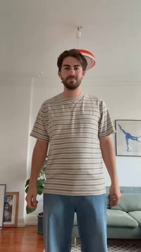 Camiseta de manga corta a rayas en tonos beige y crema con cuello redondo, combinada con jeans de un azul claro. Presenta un pequeño logo en el pecho.