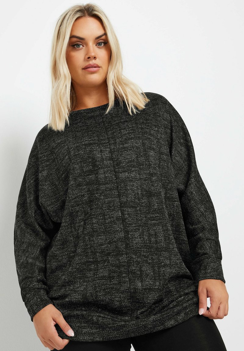 Czarny, teksturowany, oversize sweter z okrągłym dekoltem, długimi rękawami i luźnym krojem. Subtelne wzory podkreślają bogactwo materiału.