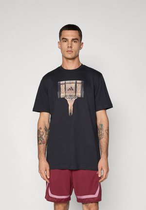 Svart bomull T-skjorte med grafikk av en basketballkurv med vevd detalj og frynser under, kombinert med maroon atletiske shorts.
