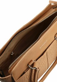 Torebka skórzana w kolorze brązowym z teksturowaną powierzchnią, z dwoma przegrodami na zamek błyskawiczny oraz srebrnymi akcentami. Wewnątrz widoczna nazwa marki "BURKELY".