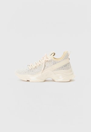 Sneakers con una parte superiore testurizzata di un beige chiaro con accenti scintillanti, suola in gomma crema spessa e sistema di allacciatura tradizionale.