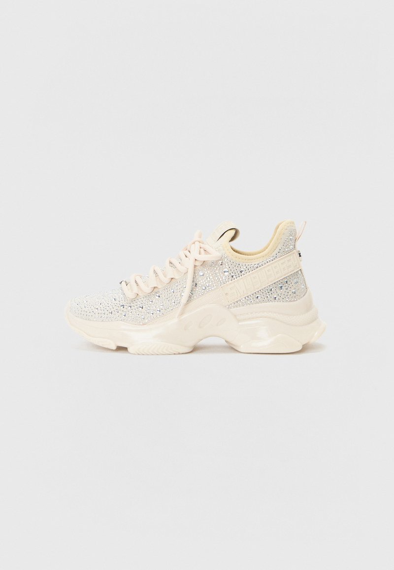 Sneakers med en teksturert lys beige overdel med glitrende detaljer, tykk kremgummisåle og tradisjonelt snøringssystem.