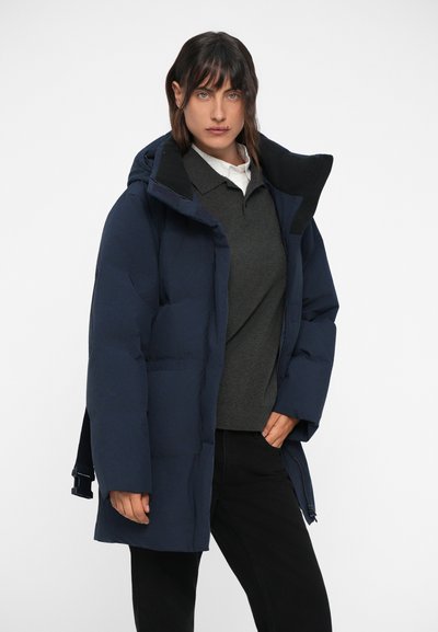 Veste rembourrée marine avec capuche, fermeture éclair à l'avant et poches latérales. Dispose d'une doublure intérieure texturée et d'un détail de taille ajustable.