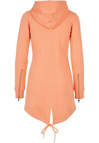 Sweat à capuche long couleur pêche avec manches longues, fermetures éclair aux poignets et cordon noué à l'ourlet arrière.