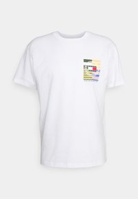 Witte katoenen t-shirt met ronde hals. Beschikt over een multicolore graphic op de linkerborst met geometrische vormen en tekst.