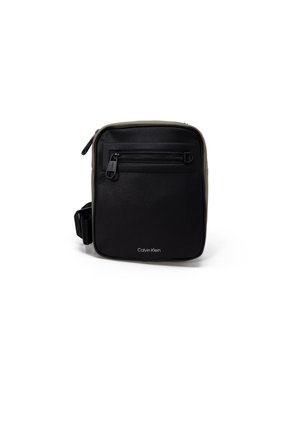 Bolso cruzado rectangular negro con superficie texturizada, bolsillo delantero con cremallera y correa ajustable. Logo de Calvin Klein en la parte frontal.
